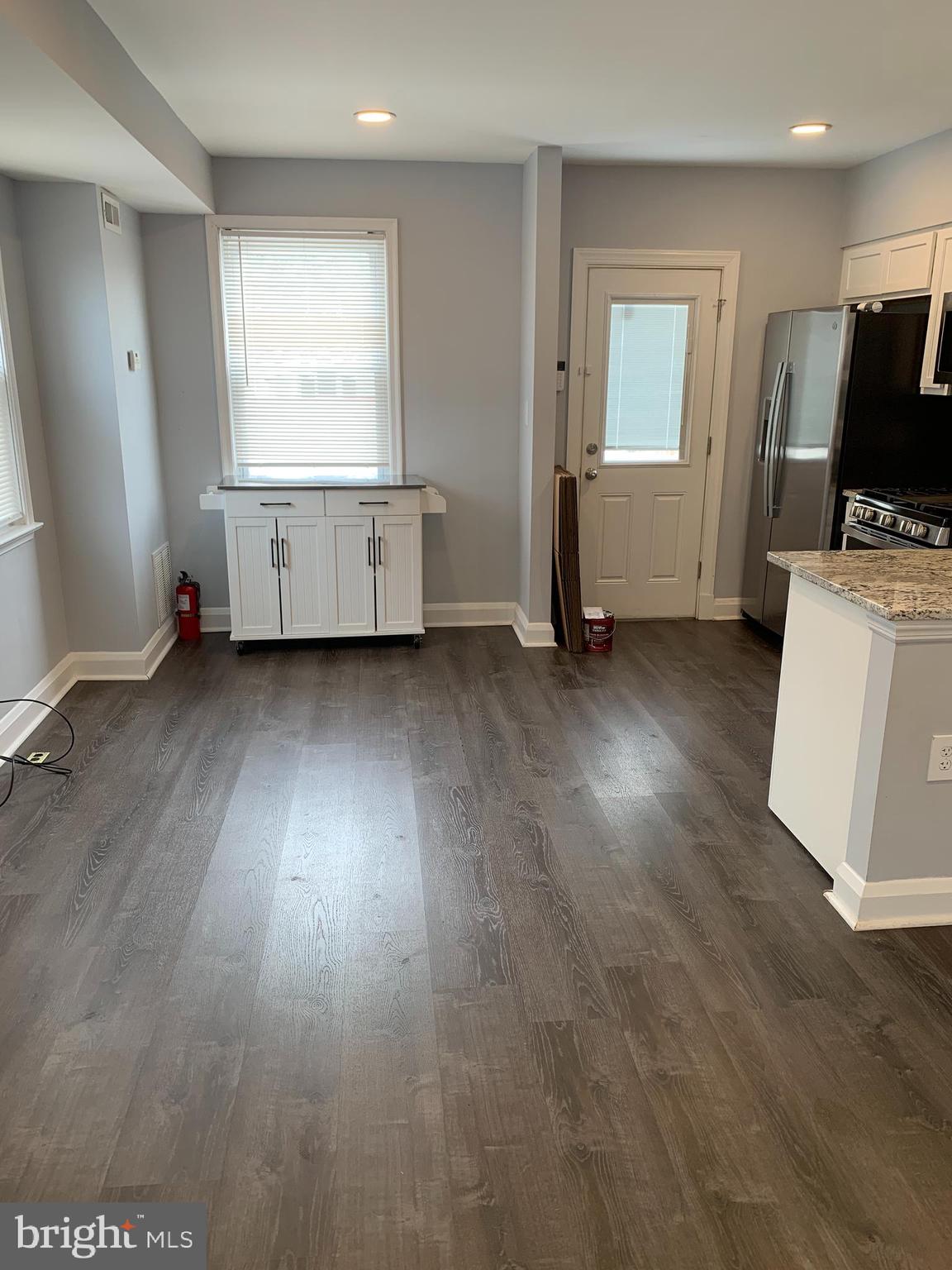 4429 Newport Avenue Baltimore, MD 21211 - Photo 3 of 17 an empty room with wooden floor cabinet and windows