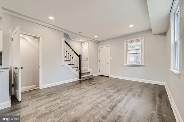 an empty room with wooden floor and entryway