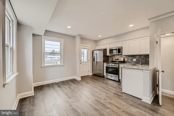 a kitchen with white cabinets and stainless steel appliances
