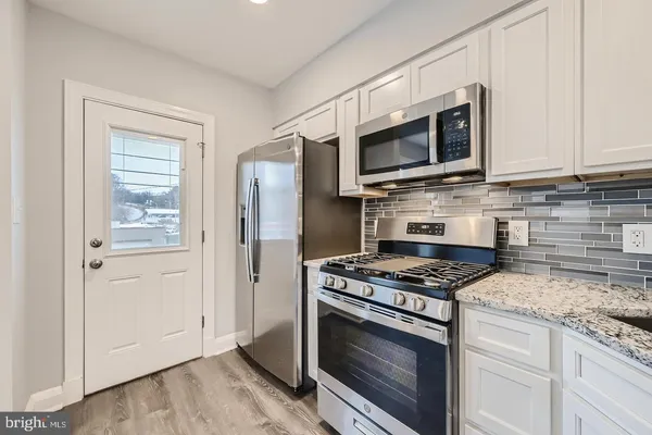 a kitchen with stainless steel appliances granite countertop a stove microwave and refrigerator