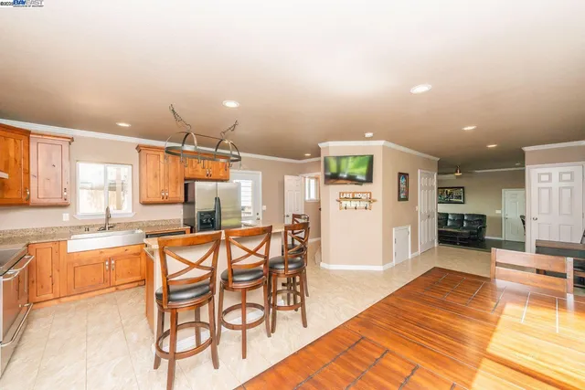 a kitchen with stainless steel appliances kitchen island granite countertop a table and chairs in it