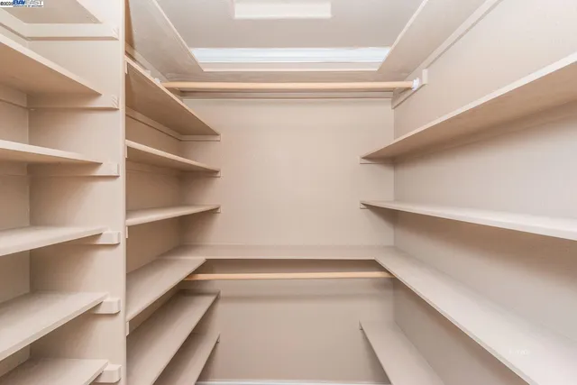 a view of walk in closet with empty racks