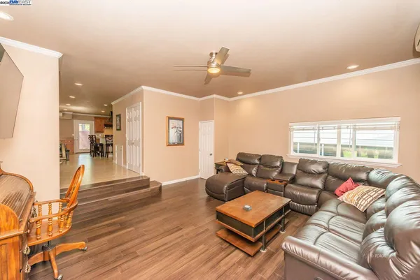 a room with furniture pool table and large windows
