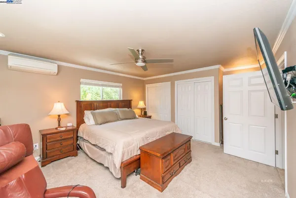 a bedroom with a bed lamp and a large window