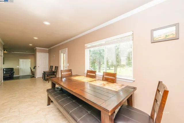 a room with furniture pool table and large windows