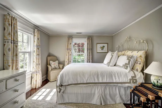 a spacious bedroom with a bed a couch and large window