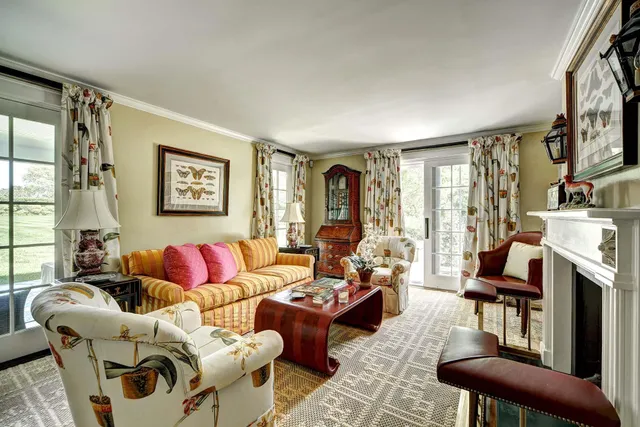 a living room with furniture fireplace and a large window