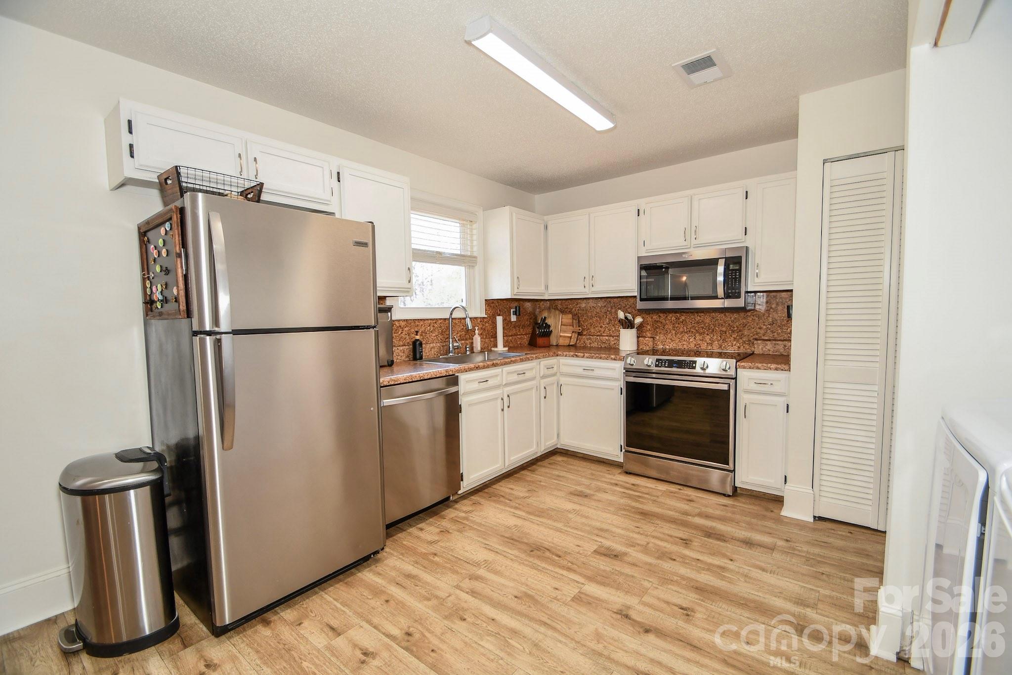1925 Sojourn Road Marshville, NC 28103 - Photo 28 of 41 a kitchen with a refrigerator a stove top oven a sink and dishwasher