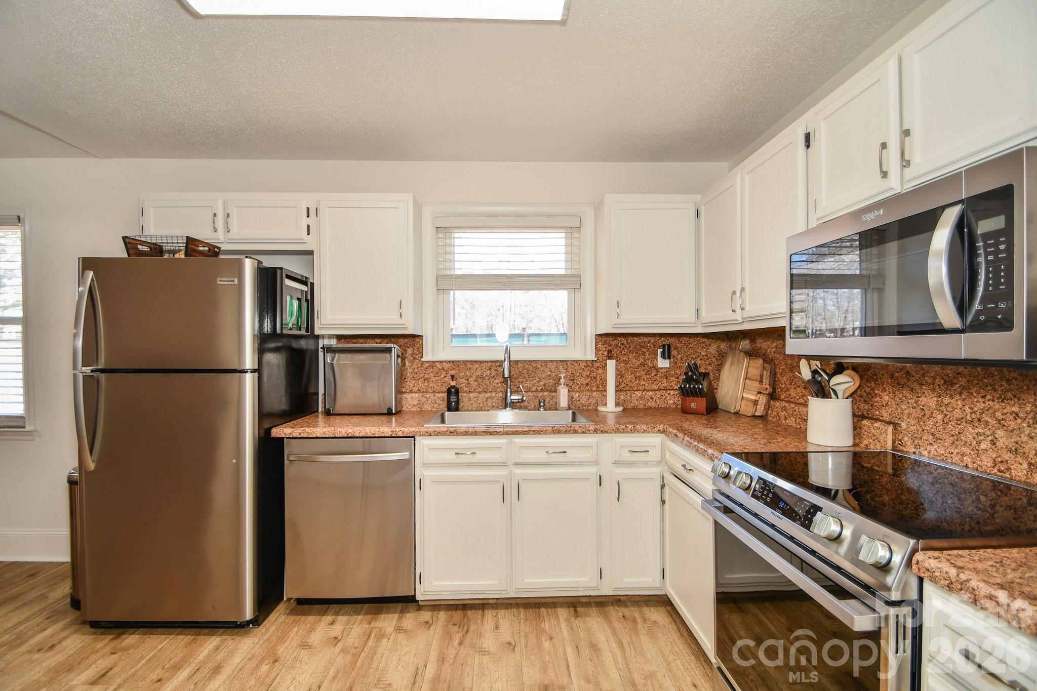 1925 Sojourn Road Marshville, NC 28103 - Photo 29 of 41 a kitchen with a sink a refrigerator a microwave and cabinets