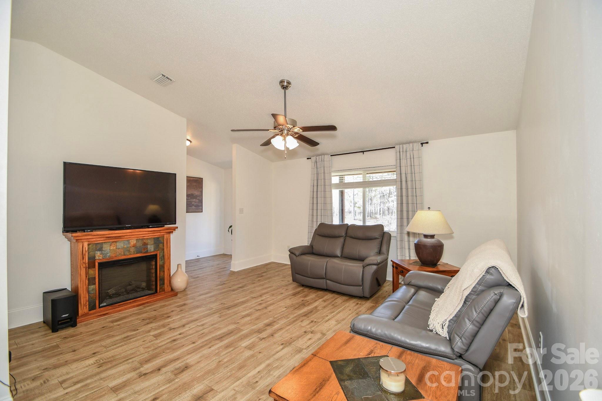 1925 Sojourn Road Marshville, NC 28103 - Photo 32 of 41 a living room with furniture a flat screen tv and a fireplace