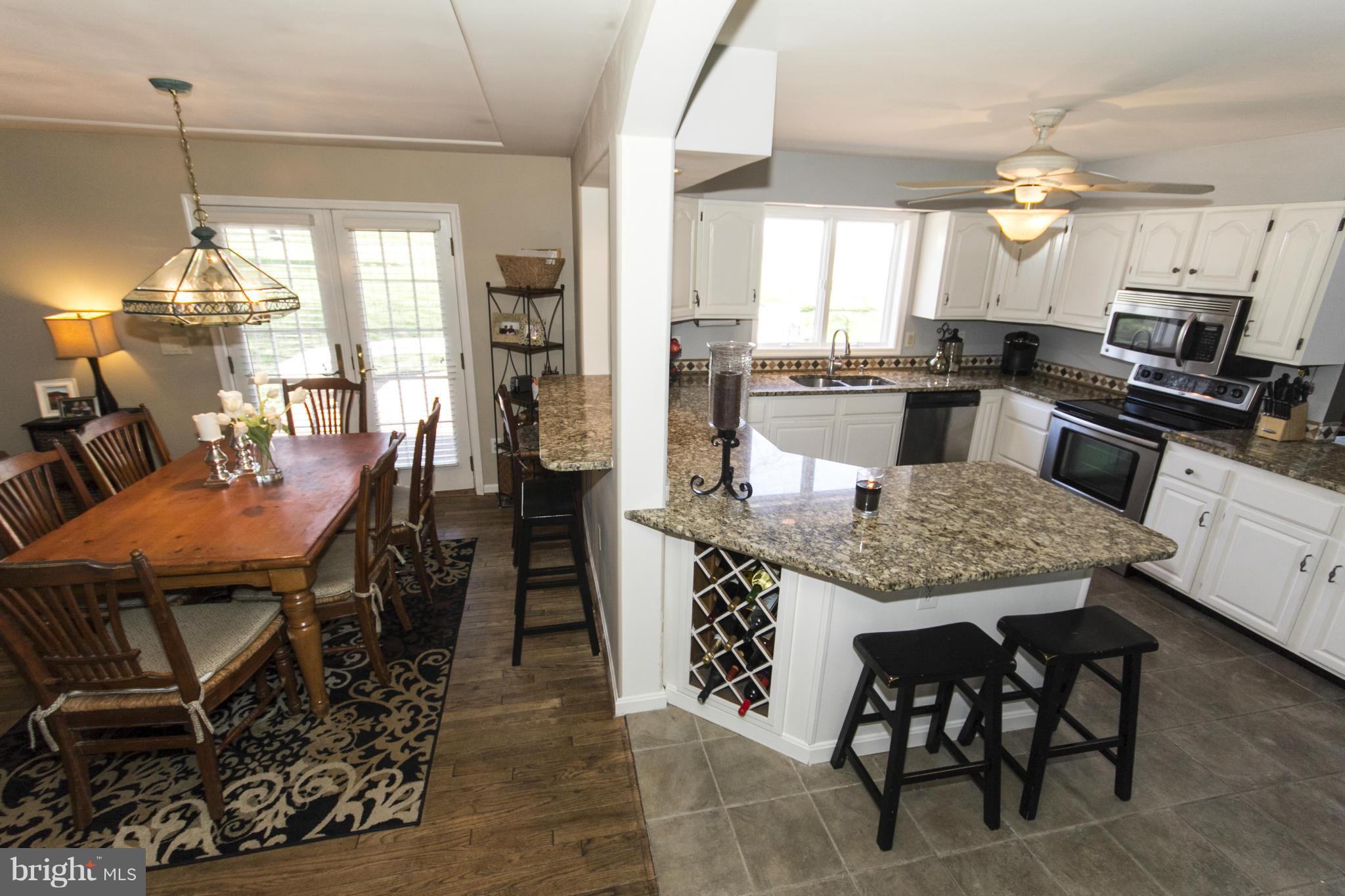 16200 Yeoho Road Sparks, MD 21152 - Photo 16 of 30 a kitchen with granite countertop kitchen island stainless steel appliances a table and chairs in it