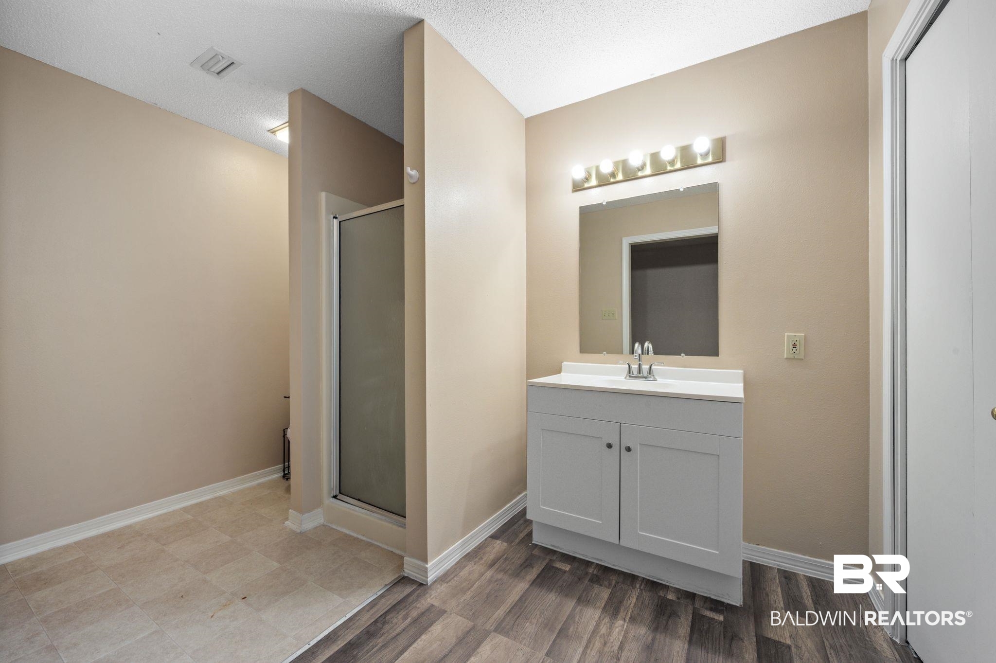 100 Orleans Way Daphne, AL 36526 - Photo 15 of 31 Bathroom with hardwood / wood-style flooring, vanity, a shower with door, and a textured ceiling