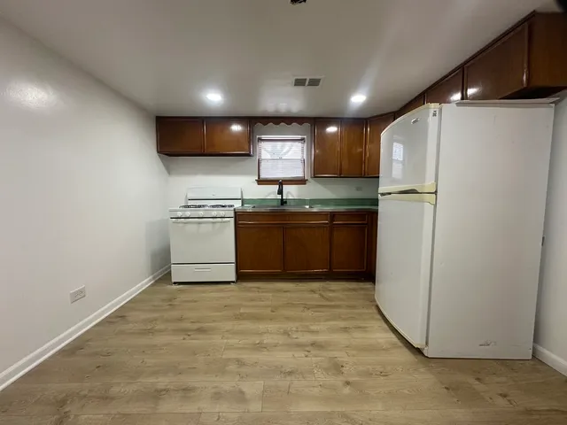a kitchen with kitchen island a sink appliances and cabinets