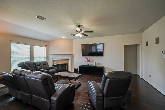 a living room with furniture a fireplace and a flat screen tv