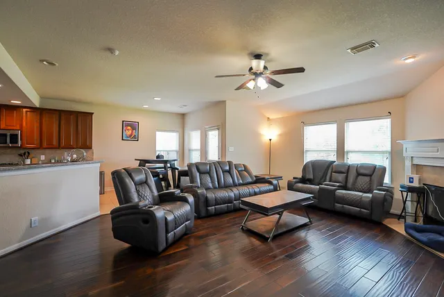 a living room with furniture and a wooden floor