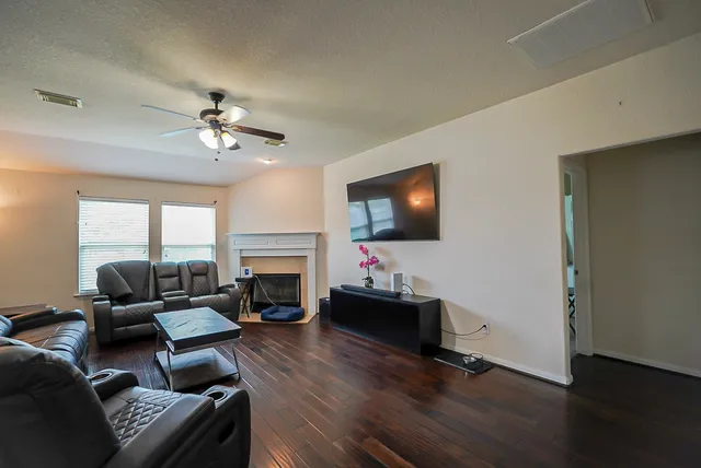 a living room with furniture a fireplace and a flat screen tv