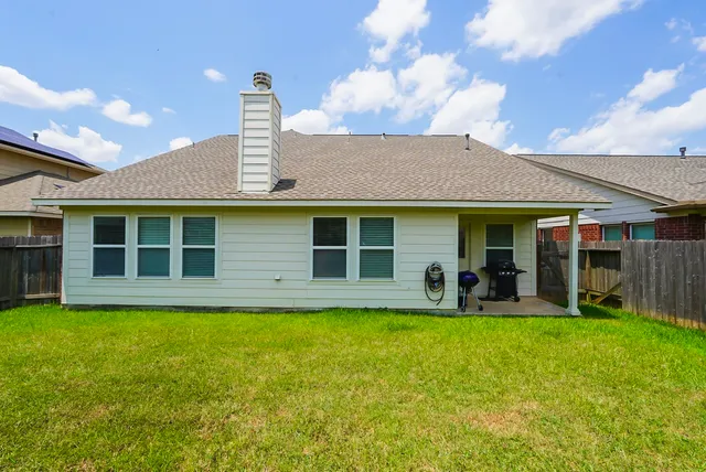 an aerial view of a house with a garden and trees
