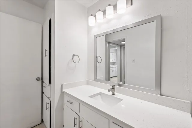 a bathroom with a sink vanity and mirror