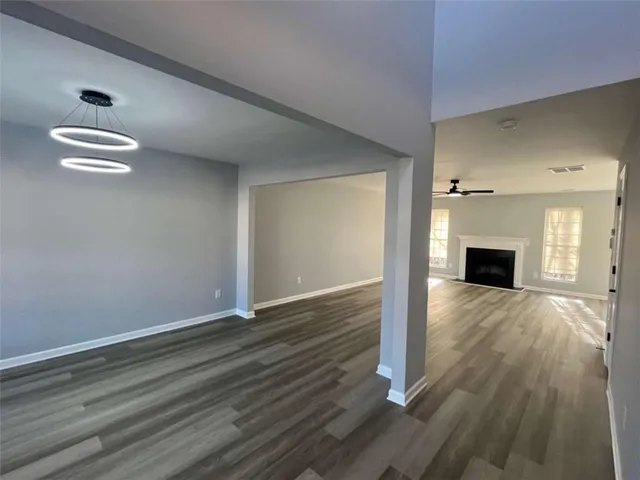 a view of a hallway with wooden floor and staircase