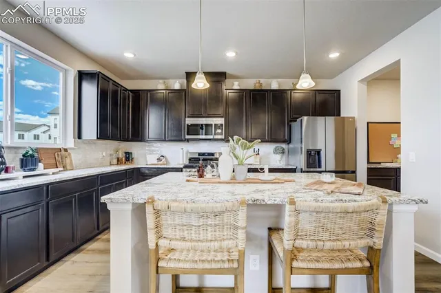 a kitchen with kitchen island granite countertop a sink stove and refrigerator
