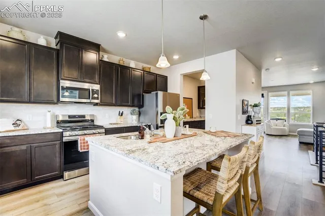 a kitchen with kitchen island granite countertop wooden cabinets a stove a sink and a refrigerator