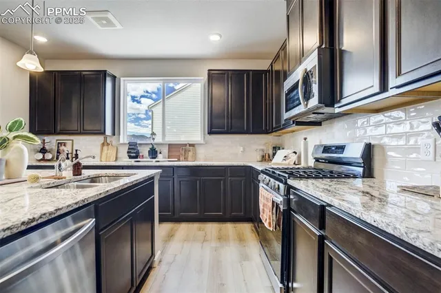 a kitchen with stainless steel appliances granite countertop a sink stove and cabinets