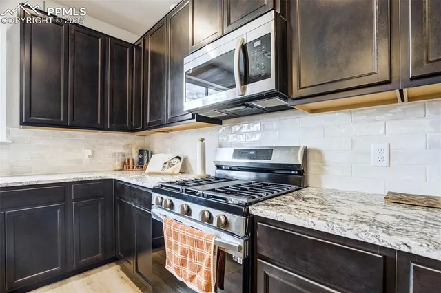 a kitchen with stainless steel appliances granite countertop a stove and a microwave