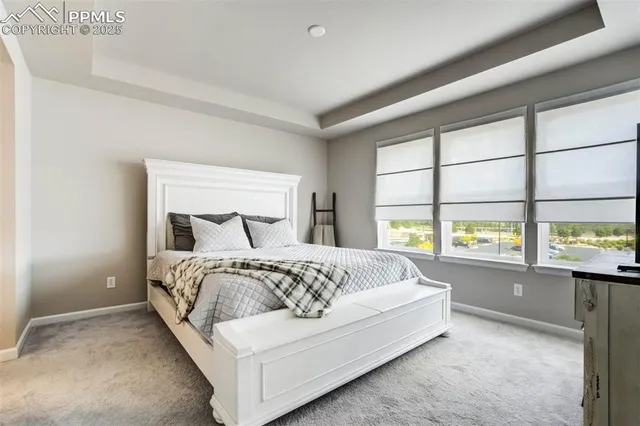 a bedroom with a bed and a flat tv screen next to a window