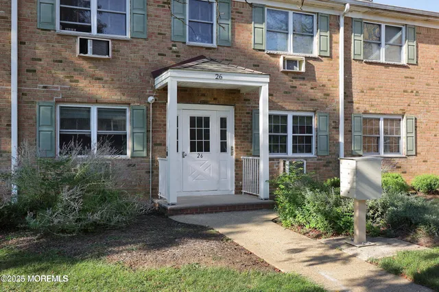 front view of a brick house with a yard