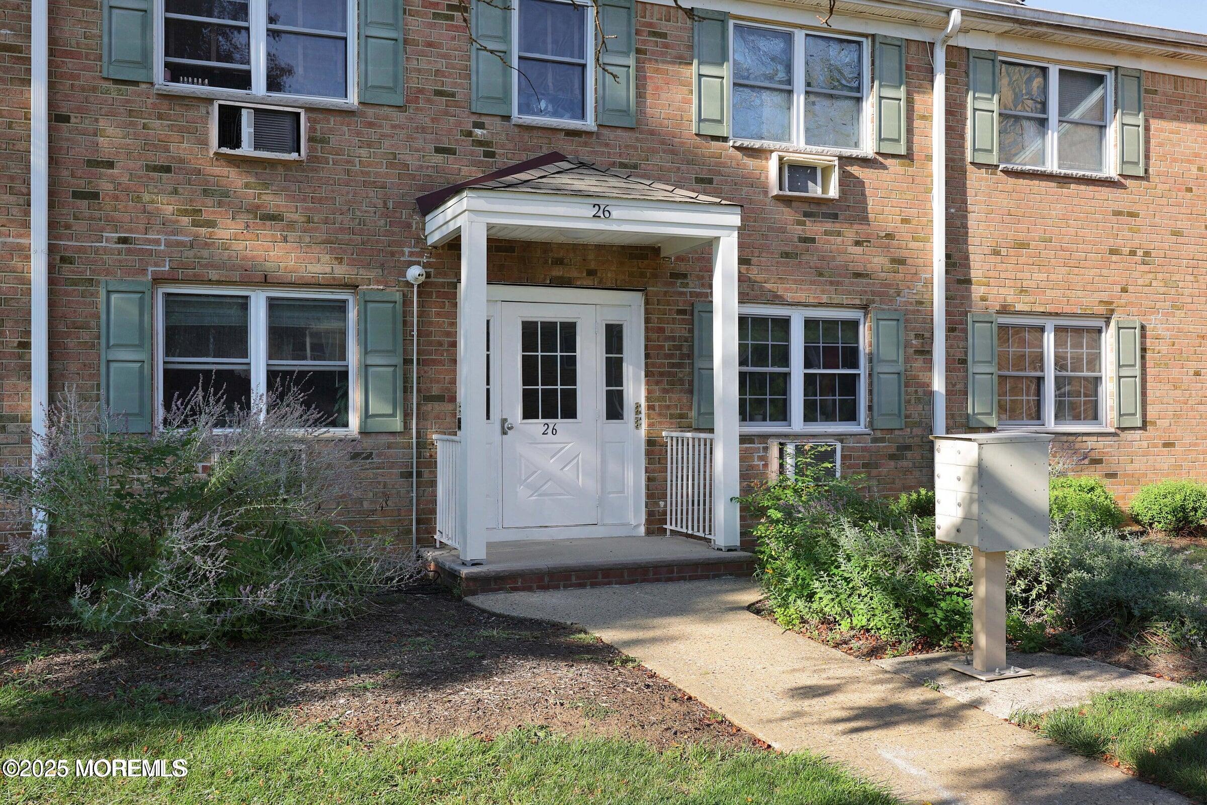 26 Windsor Terrace, Unit G Freehold, NJ 07728 - Photo 4 of 15 front view of a brick house with a yard