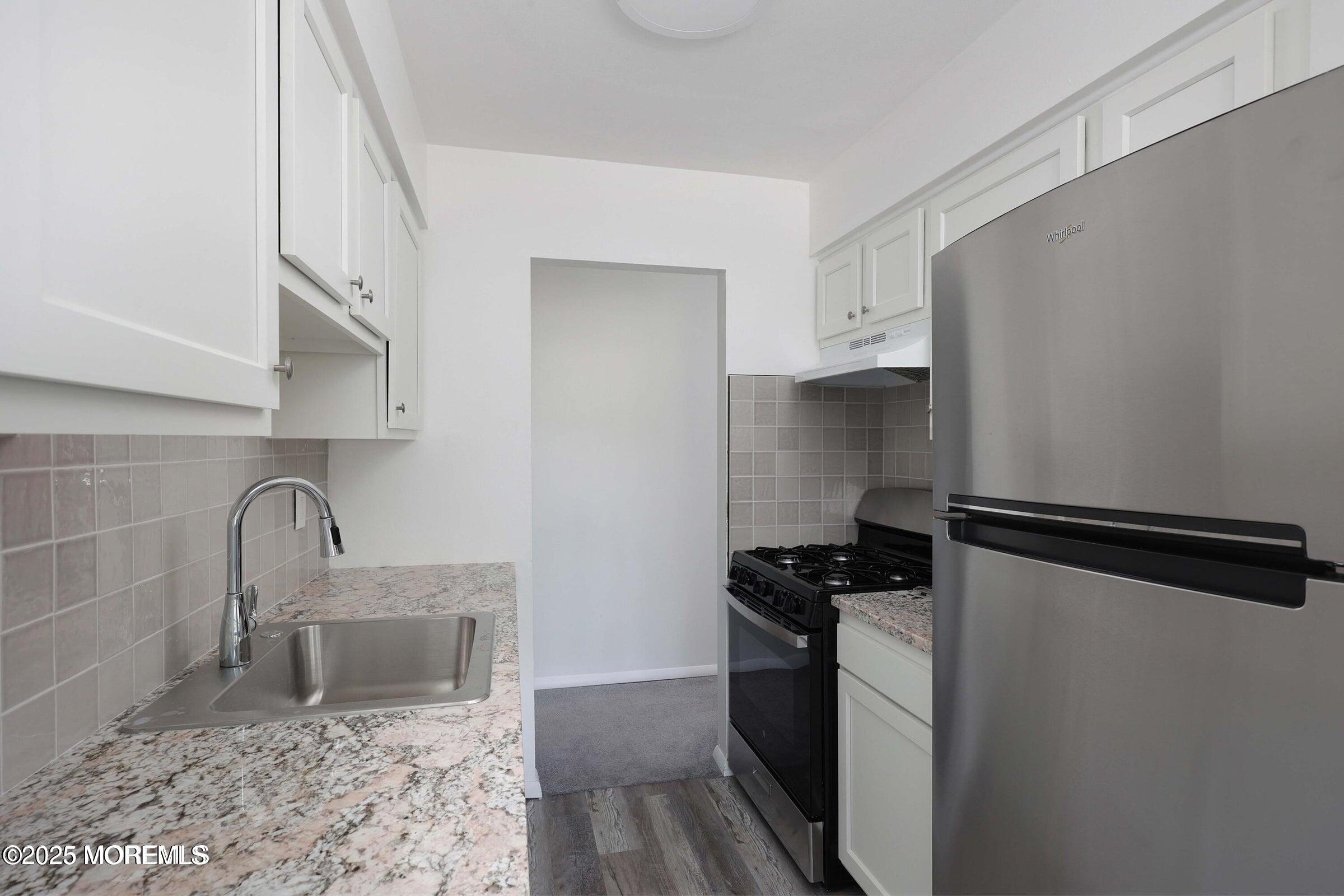 26 Windsor Terrace, Unit G Freehold, NJ 07728 - Photo 5 of 15 a kitchen with a refrigerator and a sink