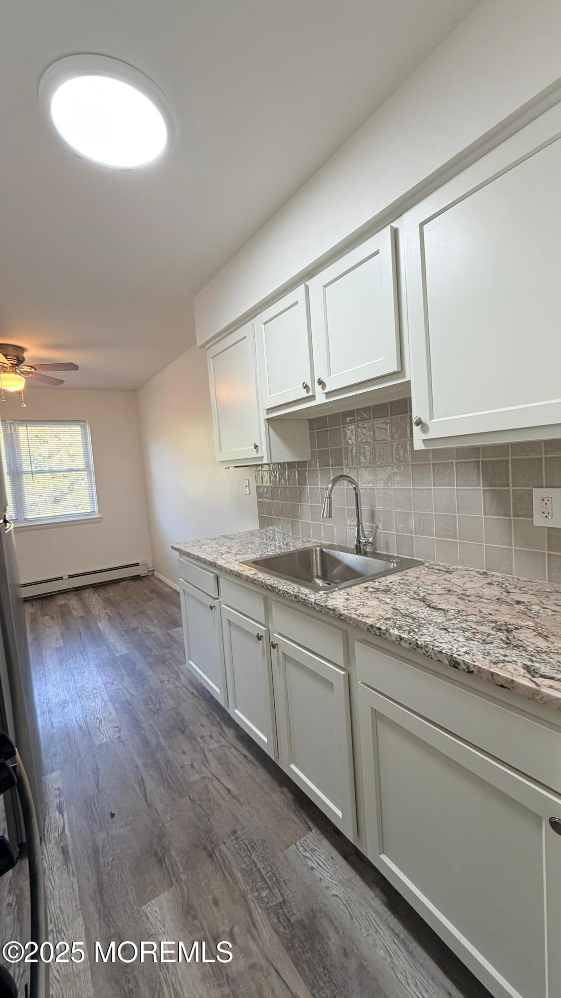 26 Windsor Terrace, Unit G Freehold, NJ 07728 - Photo 7 of 15 a kitchen with granite countertop a sink window and cabinets