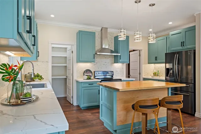 a kitchen with stainless steel appliances granite countertop a sink and a refrigerator