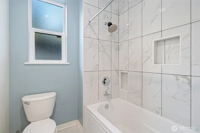 a white toilet sitting next to a bath tub