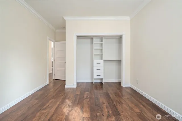 a view of empty room with wooden floor and closet