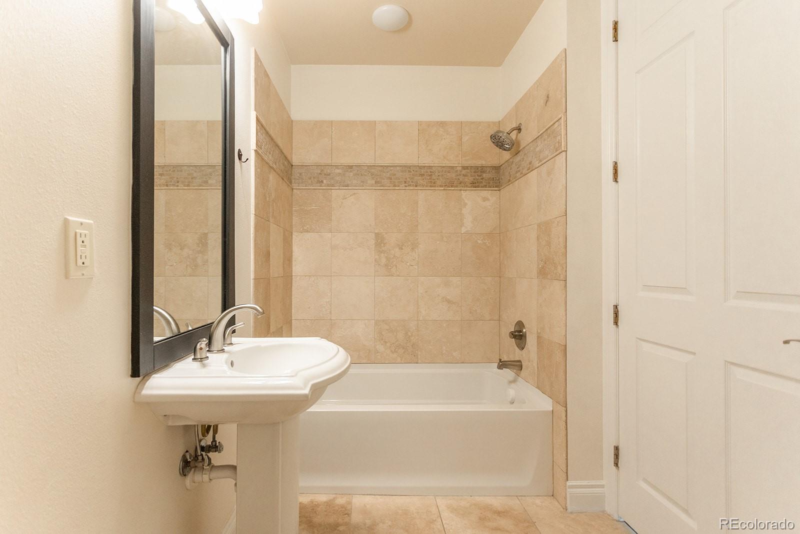 1120 Deleware, Unit 504 Denver, CO 80204 - Photo 13 of 29 a bathroom with a sink a mirror and a bathtub
