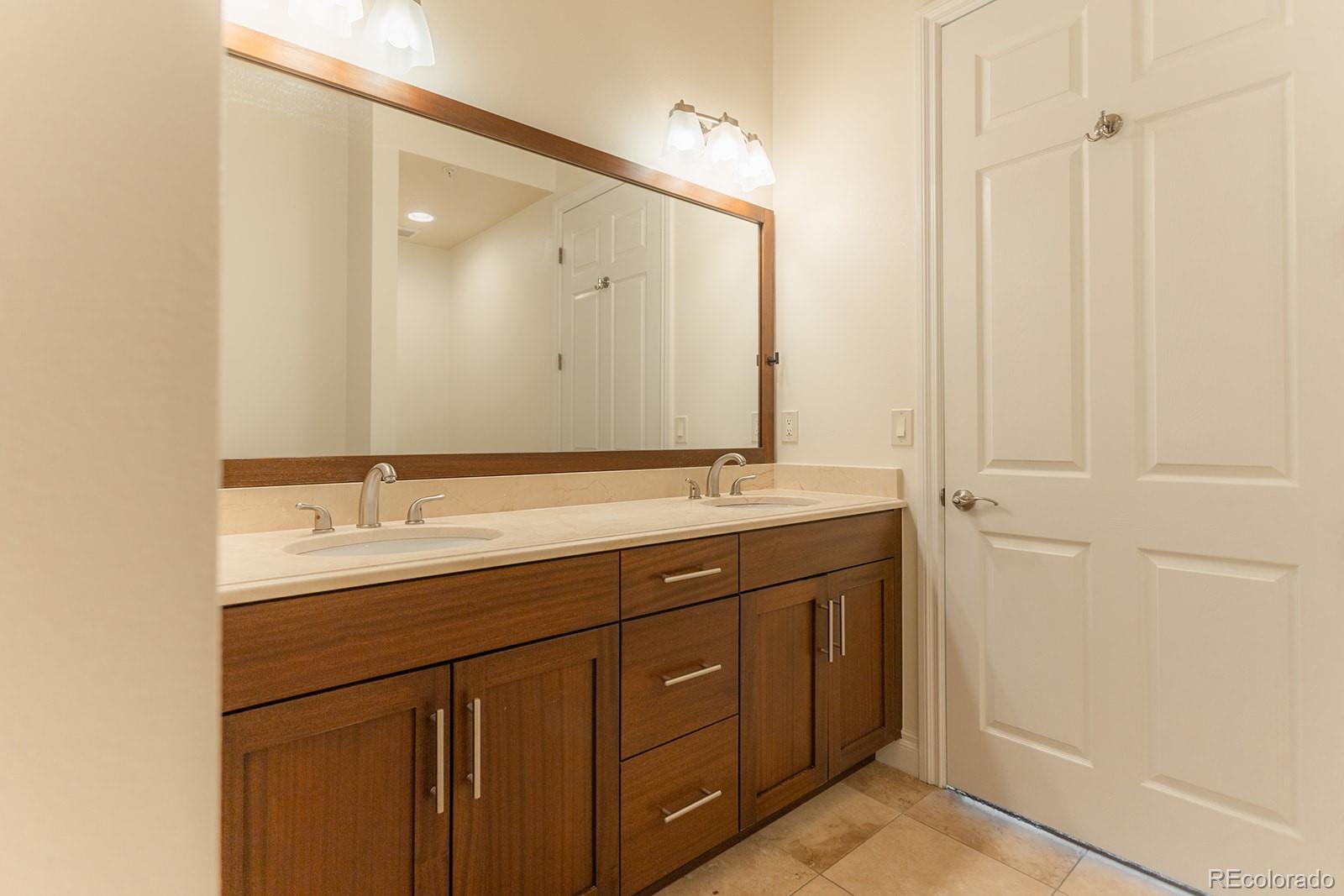 1120 Deleware, Unit 504 Denver, CO 80204 - Photo 16 of 29 a bathroom with a double vanity sink and a mirror