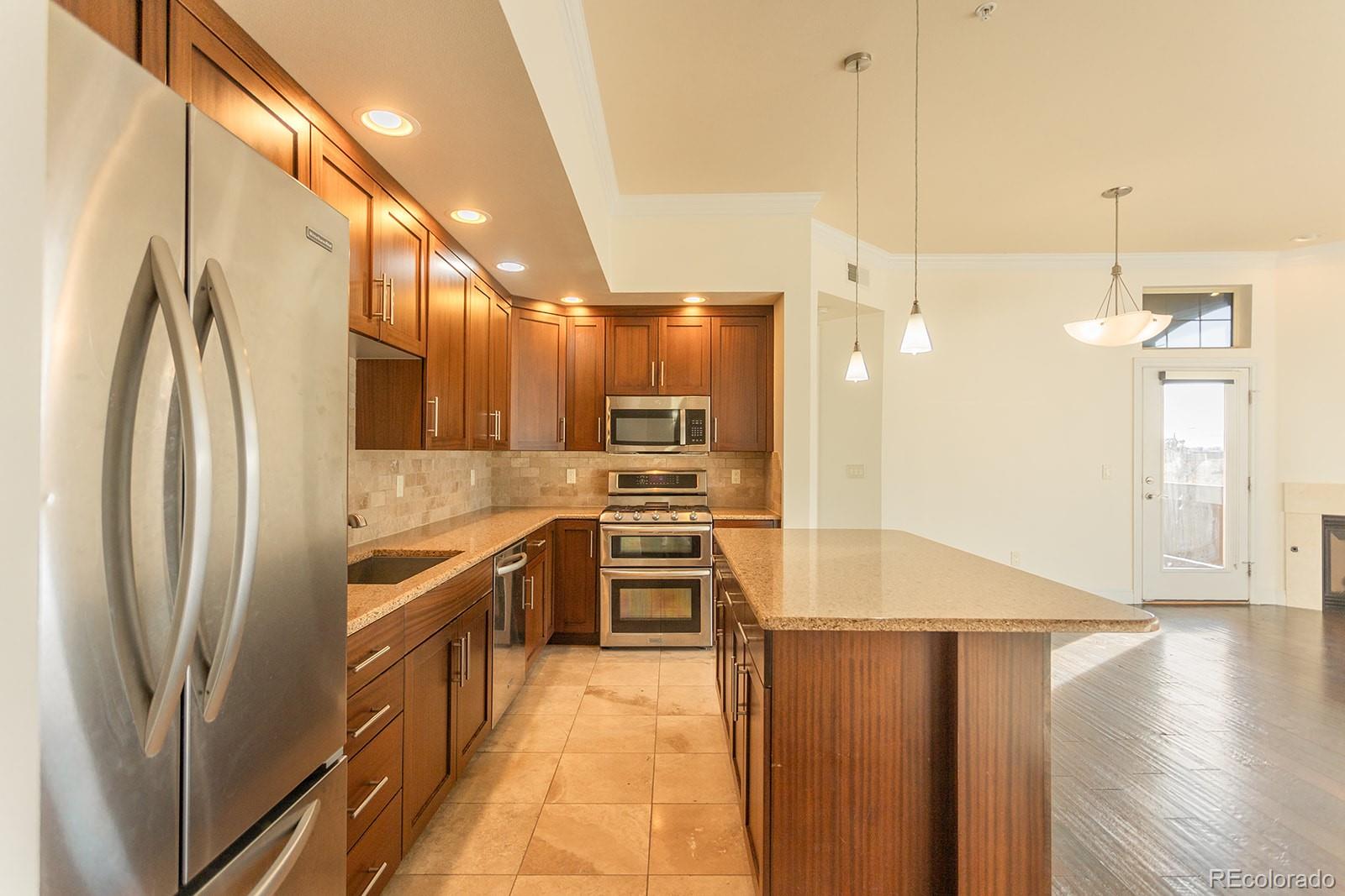 1120 Deleware, Unit 504 Denver, CO 80204 - Photo 7 of 29 a kitchen with stainless steel appliances granite countertop a refrigerator a sink and a stove