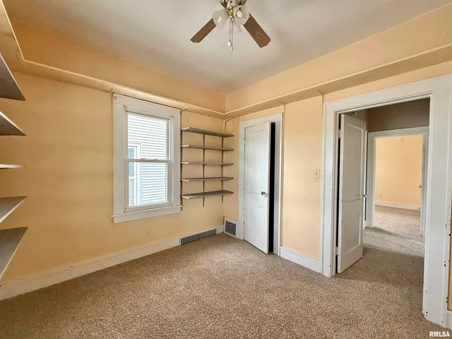 an empty room with windows and closet