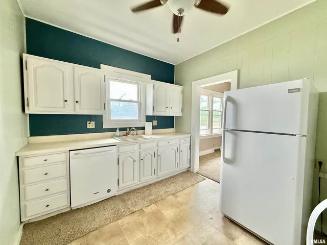 a kitchen with granite countertop cabinets appliances a sink and a window