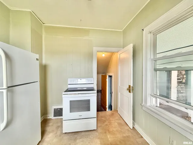 a kitchen with a refrigerator and a stove