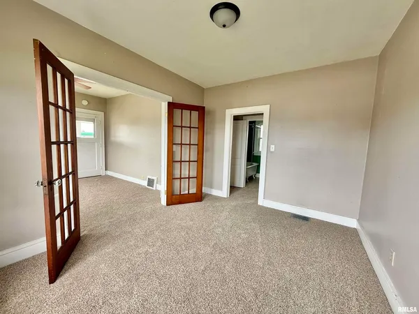 an empty room with windows and closet