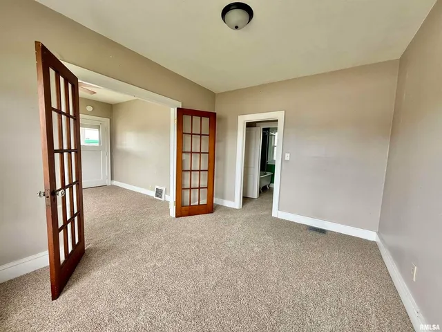 an empty room with windows and closet