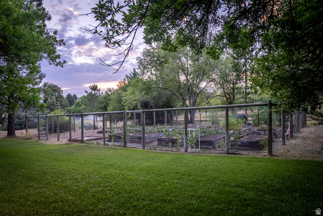 435 Canyon Road Millville, UT 84326 - Photo 53 of 113 Expansive lawn area featuring a fenced garden with multiple raised planting beds