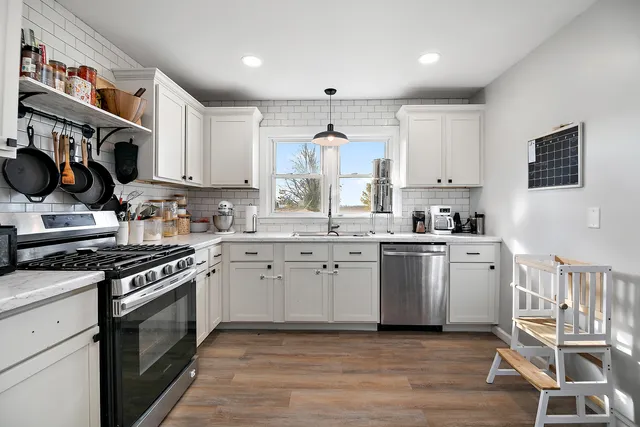 a kitchen with a white stove top oven sink and cabinets
