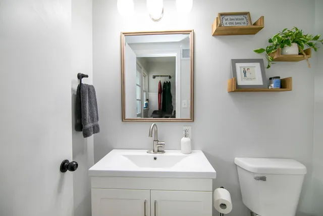 a bathroom with a sink toilet and mirror