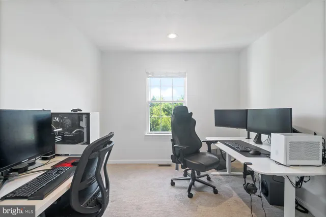 a view of a workspace with furniture and a window