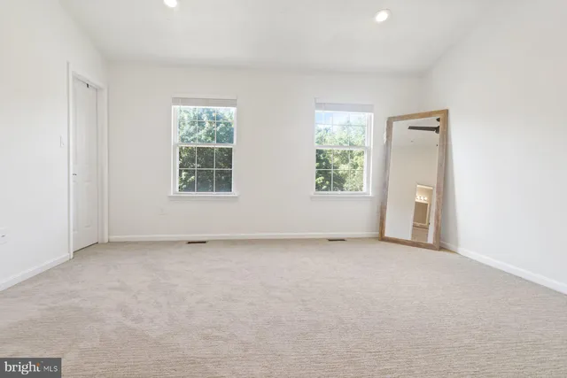 an empty room with windows and closet