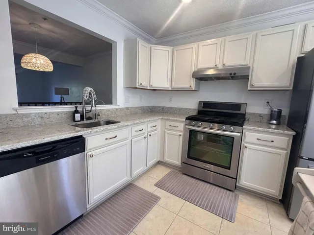 a kitchen with cabinets stainless steel appliances and a counter space
