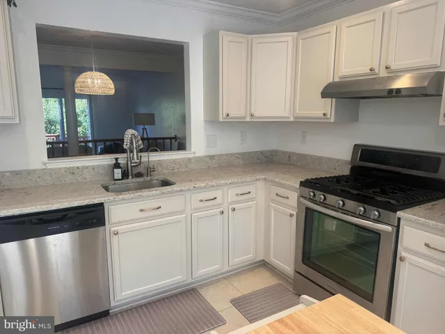 a kitchen with white cabinets and appliances